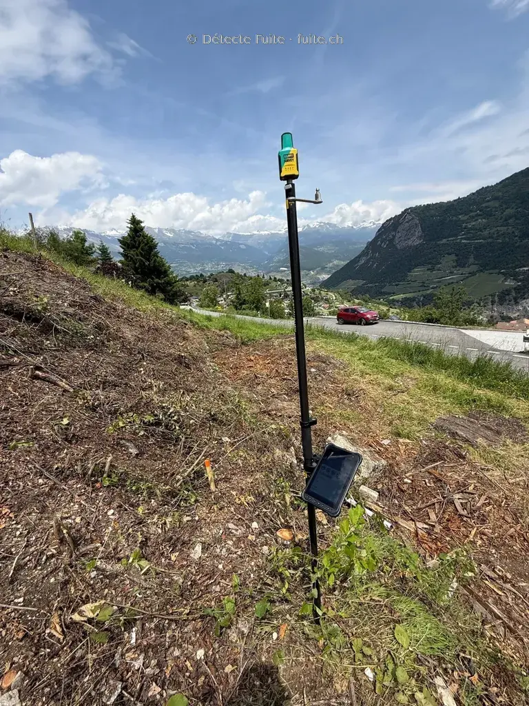 Récepteur GPS/GNSS de Détecte Fuite sur sa canne de mesure, avec son terminal, sur le terrain en Valais